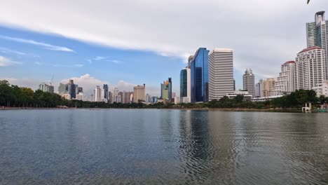 timelapse video of lake ratchada reflecting the urban cityscape of bangkok thailand at benjakitti park