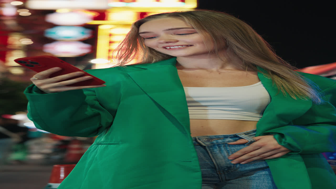 Young woman looking at phone in a city at night