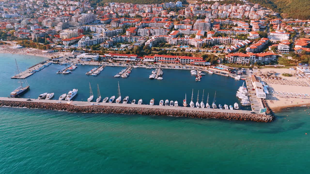Yacht club near the beachline of Sveti Vlas, Bulgaria. Multiple hotels are situated on the green slopes of the mountains. Aerial view