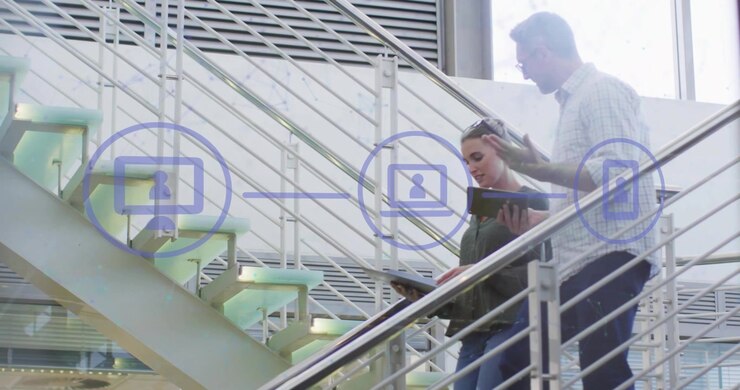 Technology professionals stepping onto stairs linking computer and phone icons collaborating