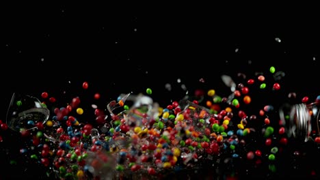 glass jar filled with colorful candy falls down and breaks