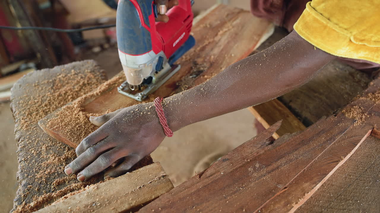 Detail black artisan sanding plank edge with sander, fine sawdust shower and hands inspecting grain and finish careful measurement, quality control and tactile craftsmanship in sunlit workshop