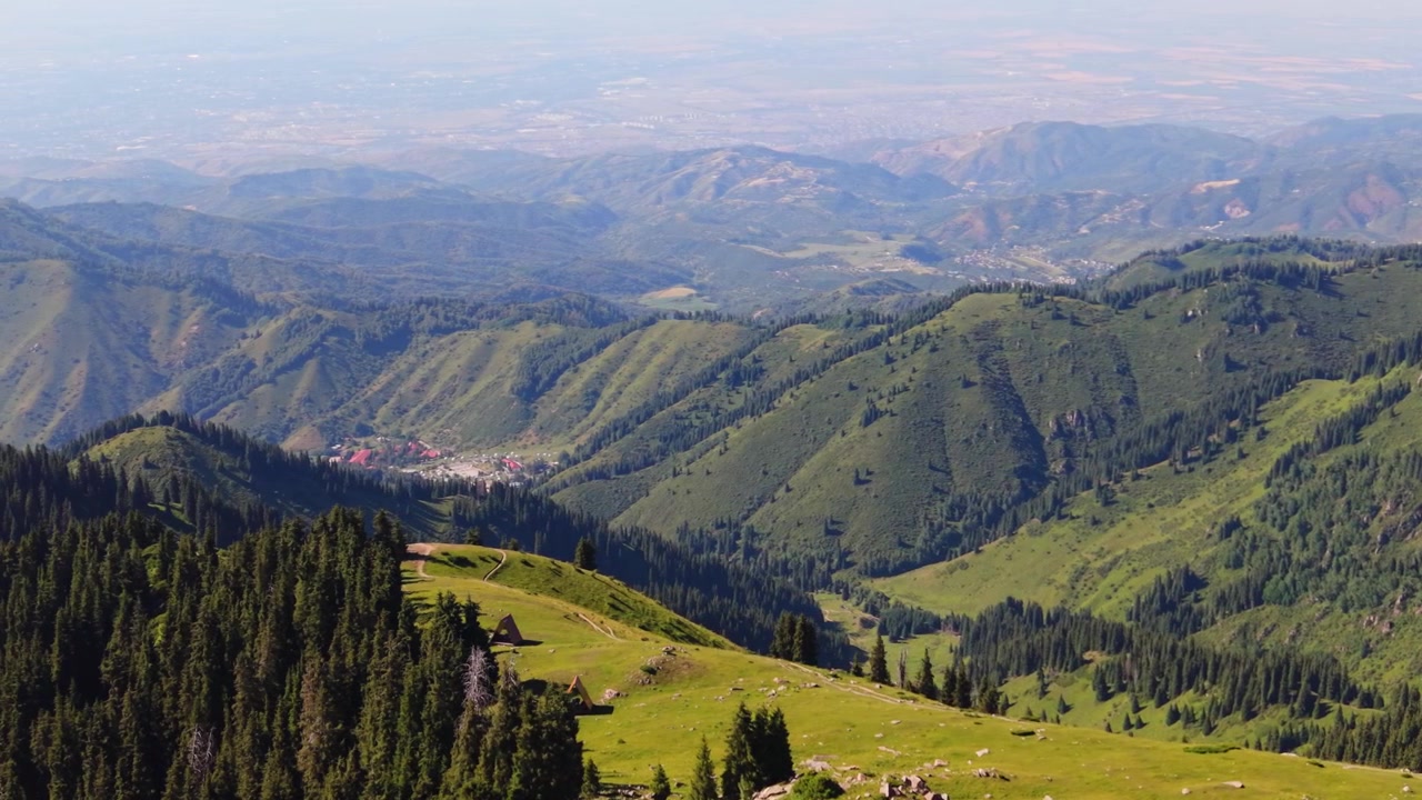 Filmisk luftoptagelse omkring campingplads på Kim Asar-ryggen i Almaty, Kasakhstan, med byen i baggrunden