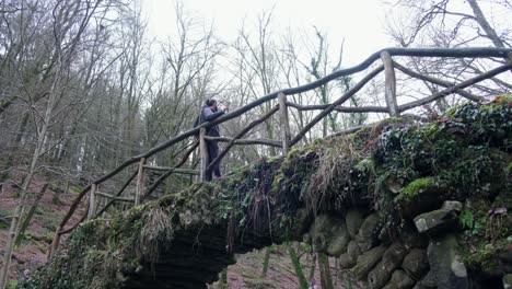 man drinking coffee at schéissendëmpel waterfall at mullerthal hiking trail in late fall season in luxembourg