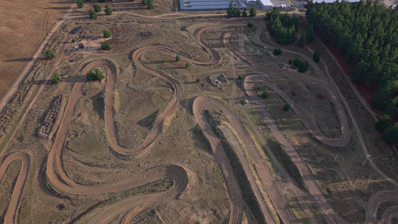High-quality aerial footage of the Central Otago Motorcycle Club motocross track in Cromwell, highlighting winding dirt circuits, jumps, and the rugged Central Otago landscape.