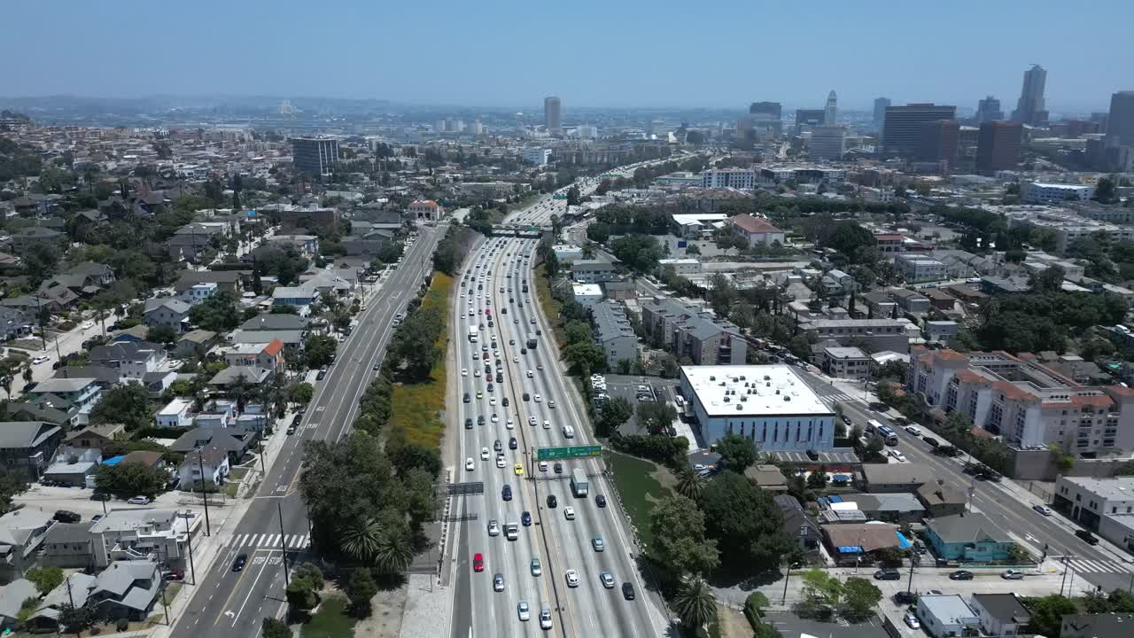 Drone flying by a busy Los Angeles freeway with cars driving near the LA skyline in 4K 60FPS. Perfect for urban, city, travel, and transportation projects