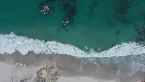 Luftaufnahme-Von-Oben-über-Den-Sauberen-Sandstrand-Von-Hout-Bay,-Wellen,-Die-Sich-An-Der-Küste-Brechen