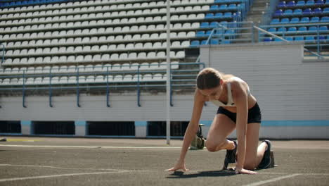 movimiento lento: atleta chica espera el comienzo de la carrera en 400 metros. atleta chica aguarda el inicio de la raza en 100 metros durante. corriendo en el estadio desde las almohadillas en la cinta de correr