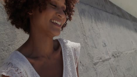 front view of young african american woman relaxing on beach in the sunshine 4k