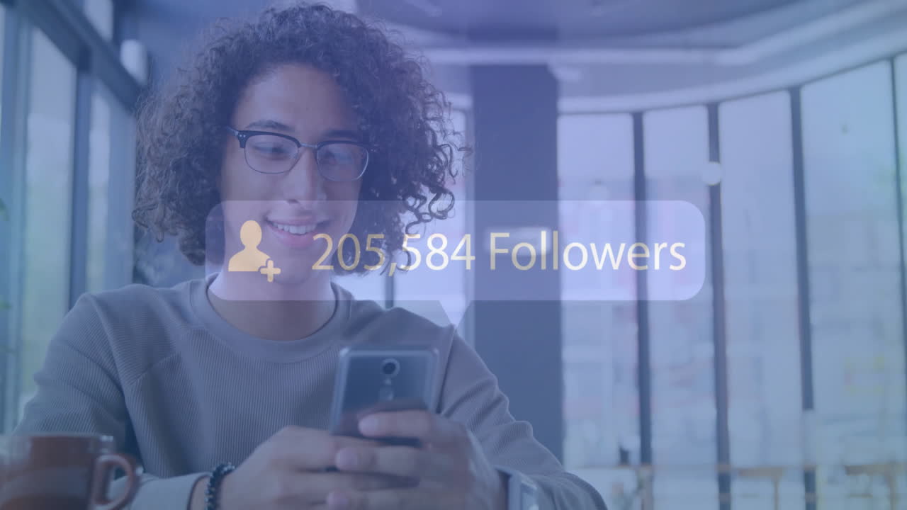 animación de seguidores de texto con un número creciente sobre el hombre biracial que utiliza el teléfono inteligente