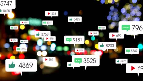 Animation-of-social-media-icons-and-numbers-over-out-of-focus-city-lights