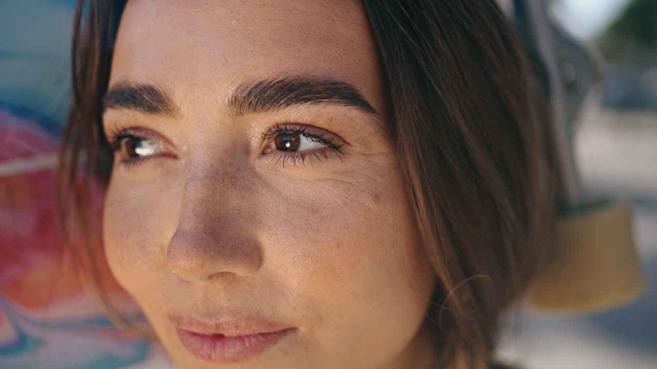 retrato de un patinador adolescente posando en un escenario urbano. mujer mirando a la cámara