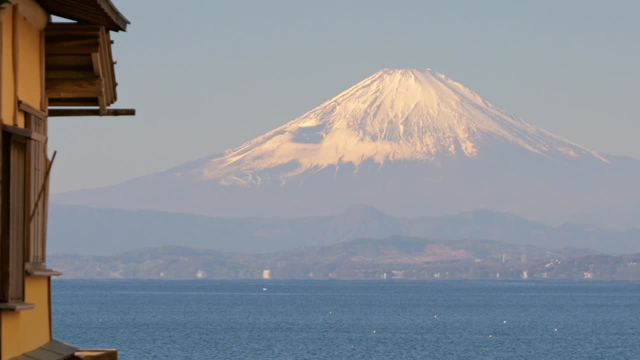 Langsom filmisk panorering over majestætiske Fuji-bjerget over Tokyo-bugtens hav