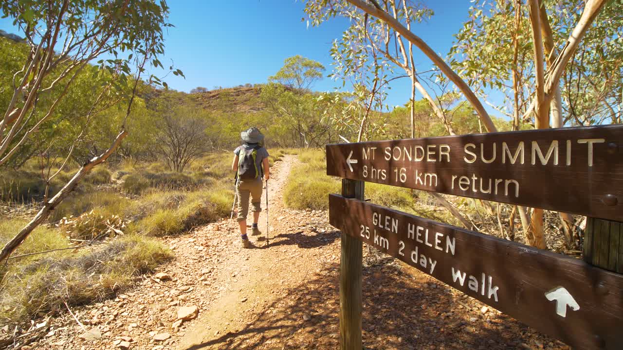 등산객이 호주 중부 라라핀타 트레일의 손더산 표지판을 지나 걸어갑니다.