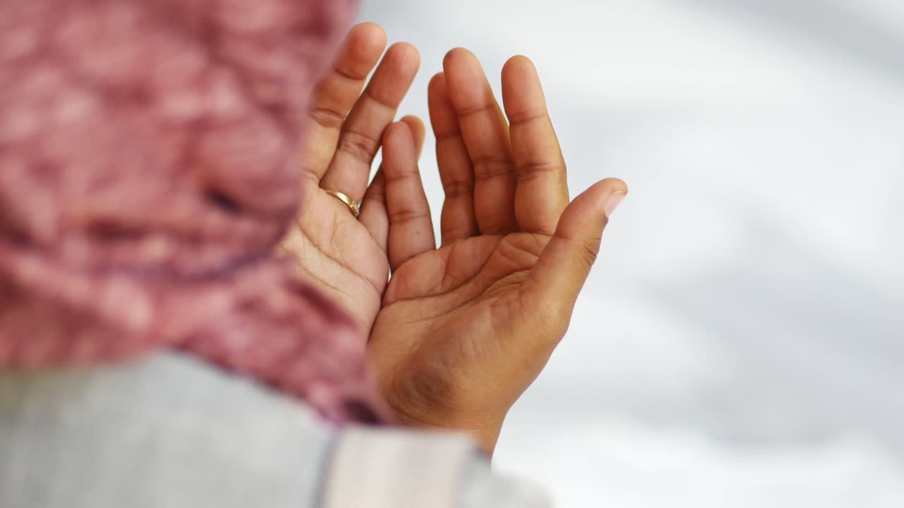 히자브 를 입은 여자 가 기도 하고 있다