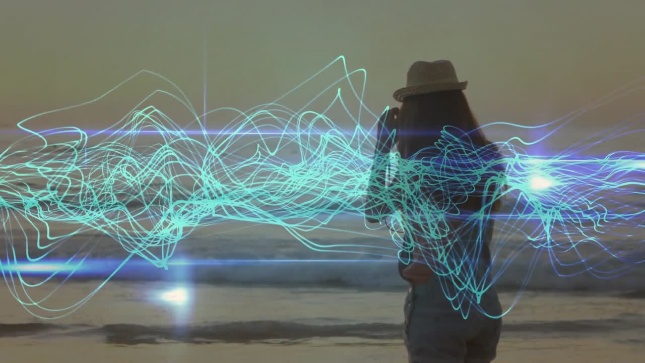 Photographer framing sunset using DSLR on beach, activating teal waveform showing scene atmosphere