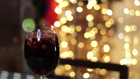 glass of clericot red wine cocktail with defocused lights background