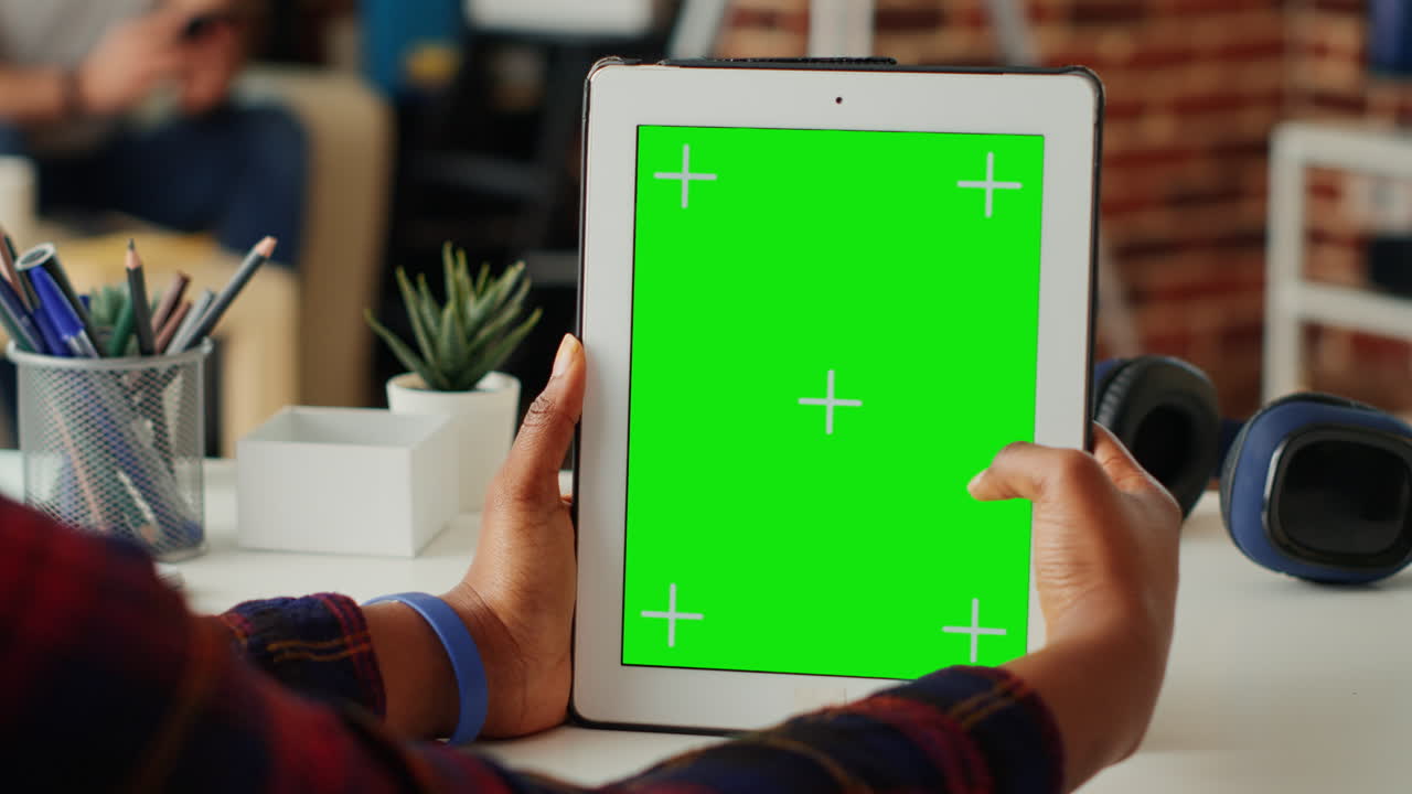 Young student using greenscreen template on digital tablet