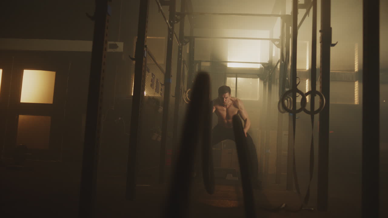 hombre trabajando con una cuerda en un gimnasio