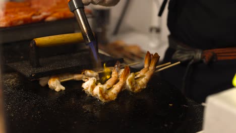 cooking shrimp skewers with a blowtorch