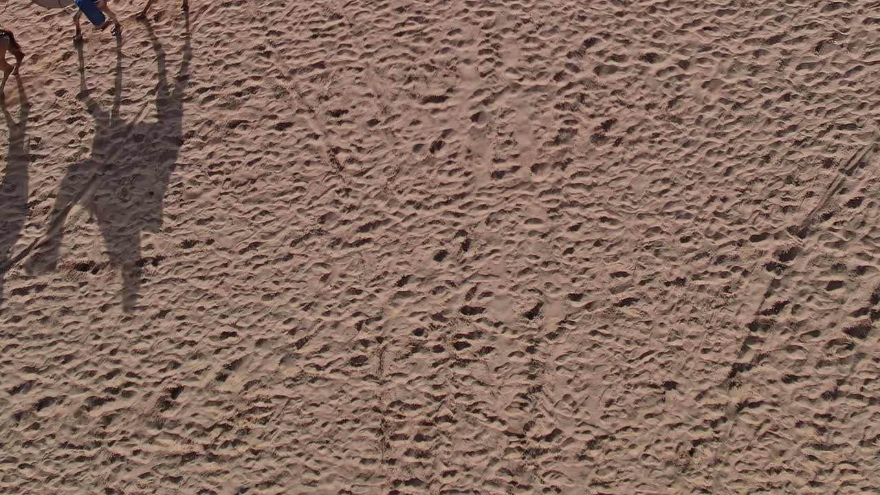 Aerial view of sandy terrain in Morocco showing patterns and trails