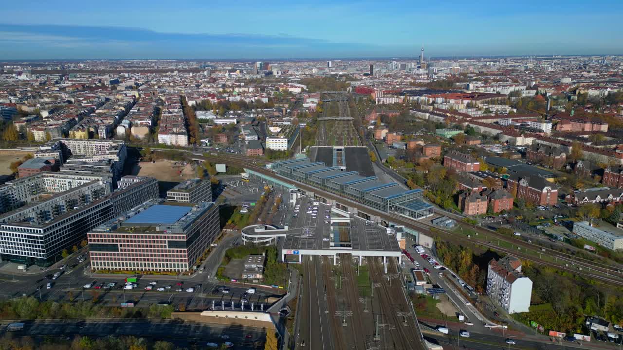 Berlin cityscape with a modern train station South Cross and extensive railway lines under a clear sky. Dramatic aerial view flight drone shot from above