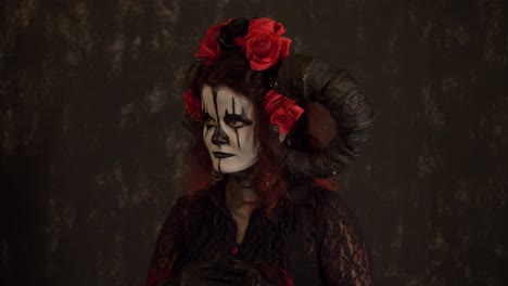 mysterious woman in dark fantasy costume with horns and red roses