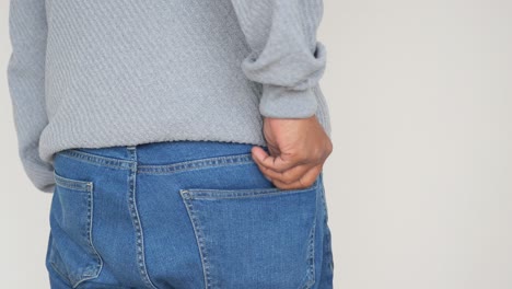 person putting wallet in back pocket