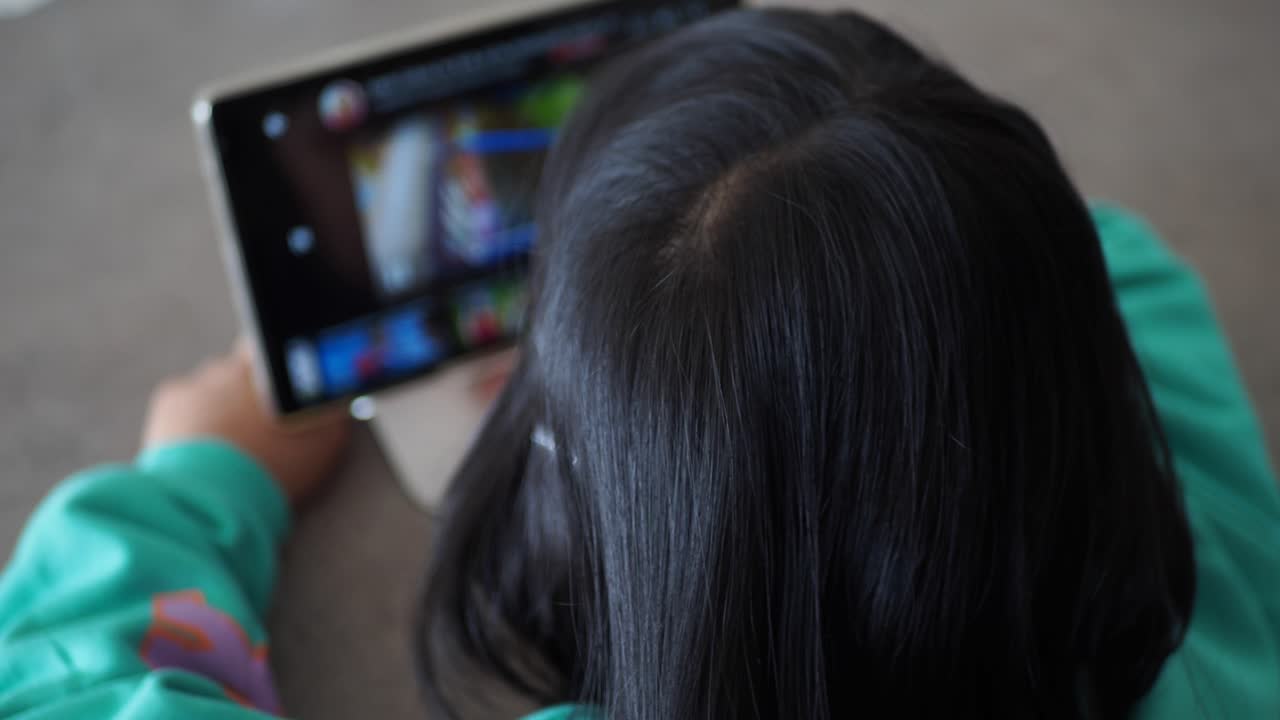 의자에 앉아 디지털 태블릿을 사용하는 아이의 뒷면, 선택적 초점,