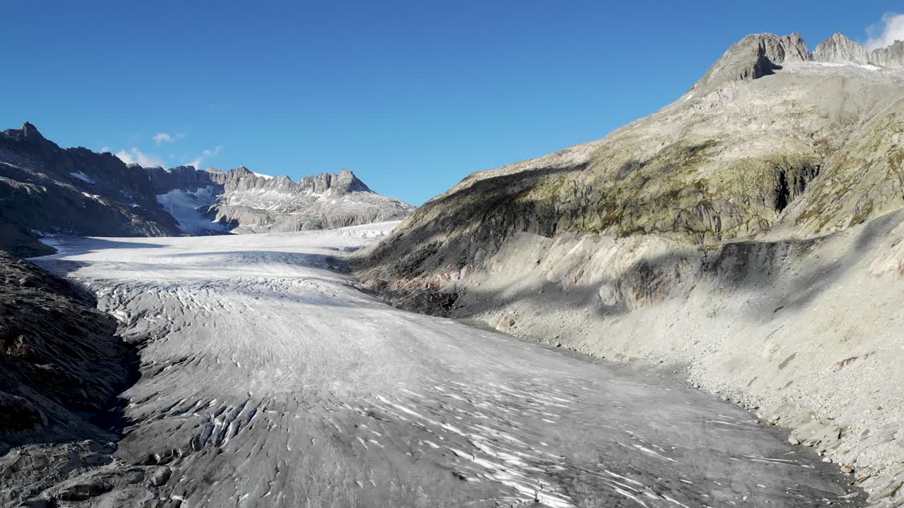 스위스의 발레와 우리의 경계에 있는 푸르카 산길 근처의 론 빙하의 공중 전망, 산봉우리에서 얼음 위로 빙산으로 가득 찬 호수까지 내려오는 팬