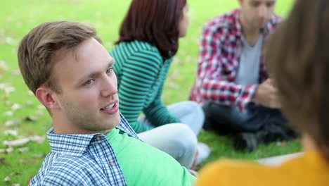 happy students chatting together on the grass