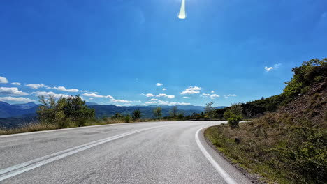 driving time lapse on a sunny day on the mountains of greece, greenland left and right of the street, colorful