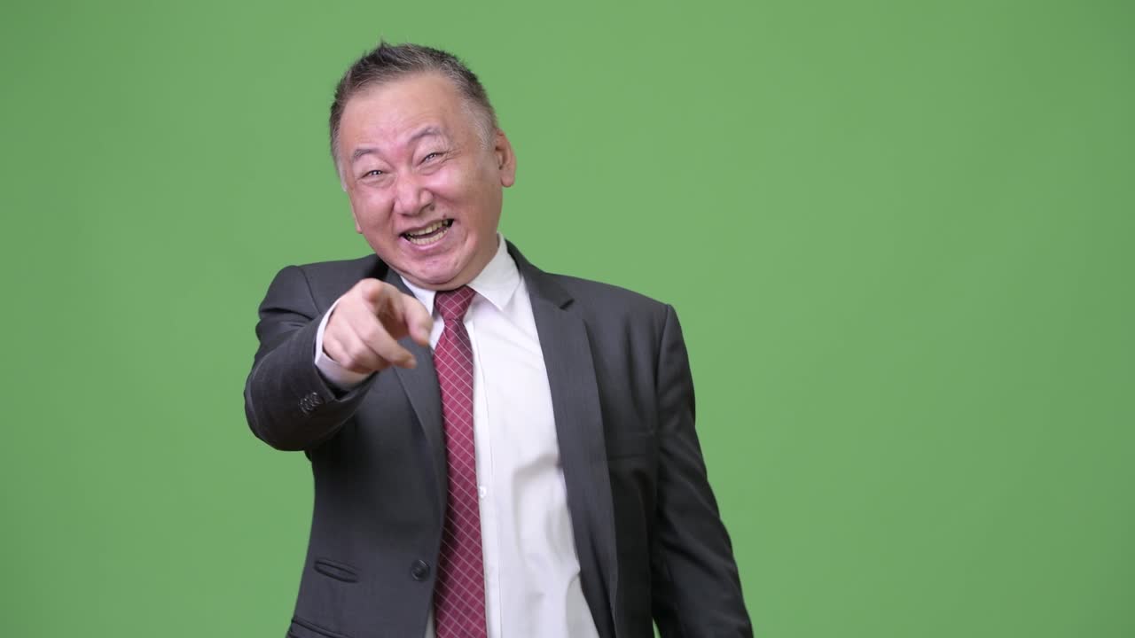 성숙 한 일본인 사업가 가 큰 소리 로 웃고 있다