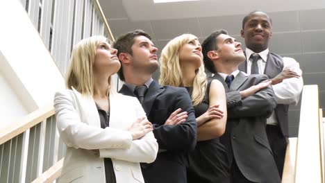 business people in a line on stairs smiling at the camera