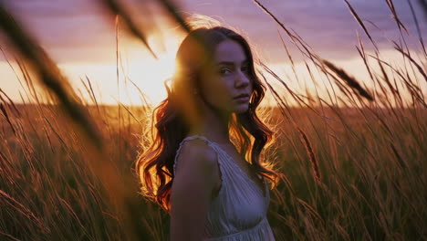 portrait of a young woman in a field at sunset