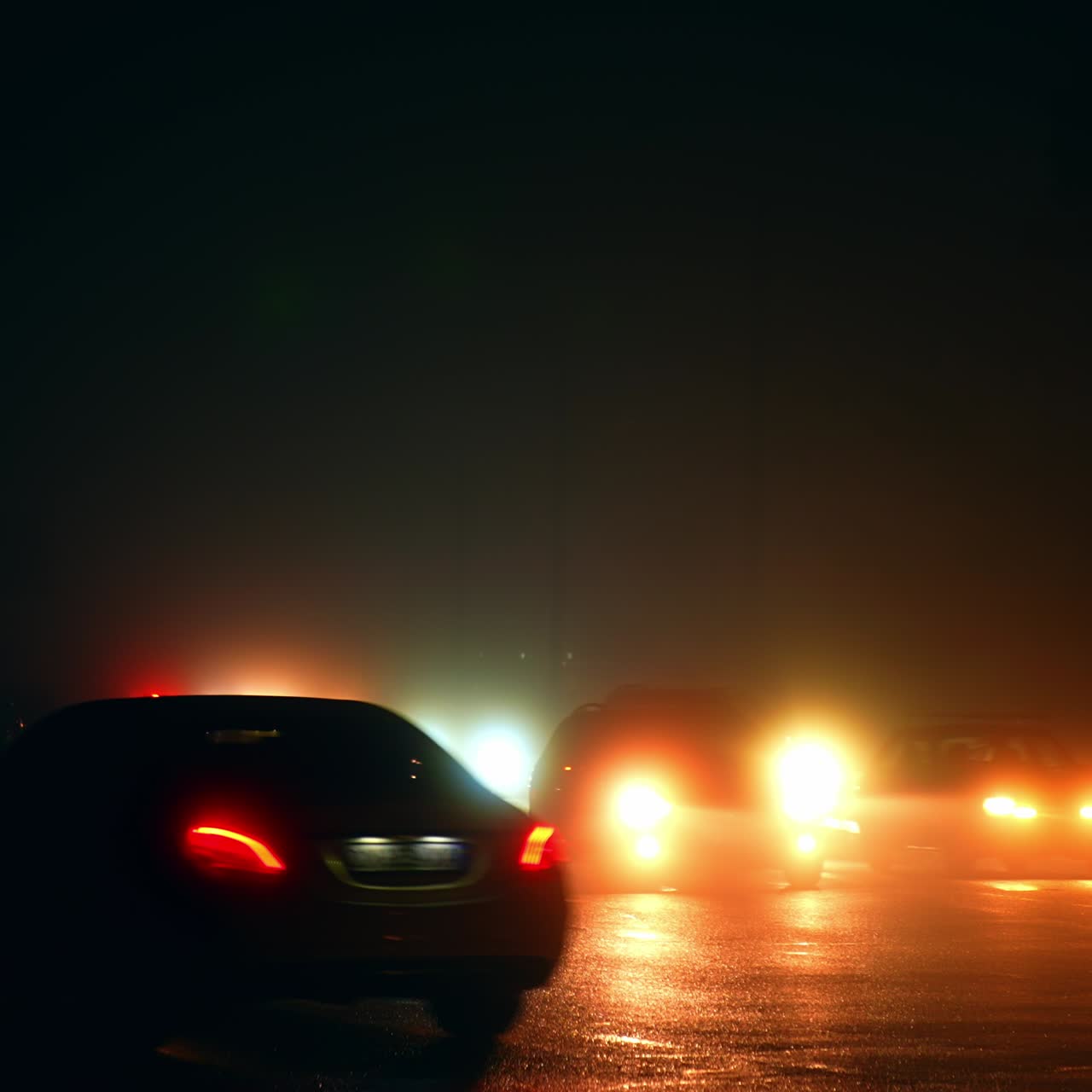 Slowly moving cars by the dark roads of the city during electricity outage. Modern city in the period of blackout power crisis