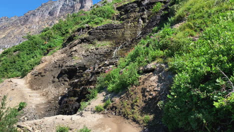 toma cerrada del arroyo que fluye a través de las montañas que rodean el valle glacial del paso de logan del sendero highline