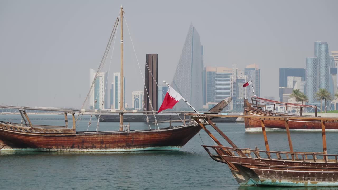 Båter med Qatar-flagg som vaier i Doha by marina og skyline