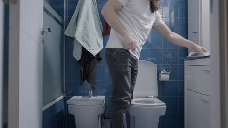 man fixing toilet in bathroom