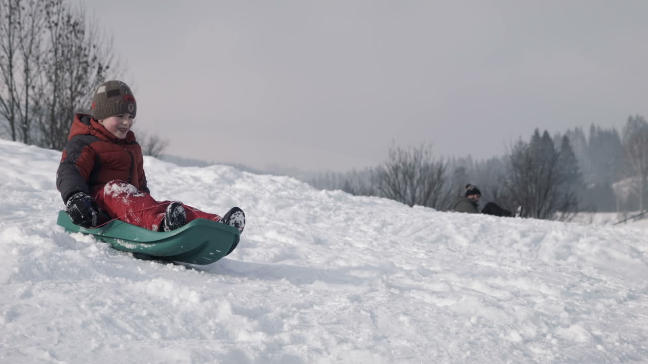 The Boy Climbs Down On a Sledge On a Hill (Stock Footage)