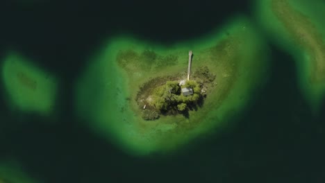 isolated island maximiliansinsel in german lake eibsee, aerial drone view