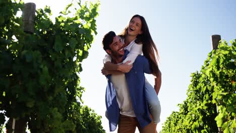 Man-giving-piggy-back-to-woman-in-the-wine-farm