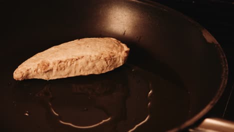 chef putting frozen vegan plantbased chicken fillets in hot frying pan