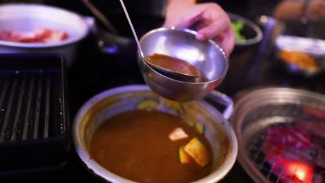 ladling kimchi soup into a bowl