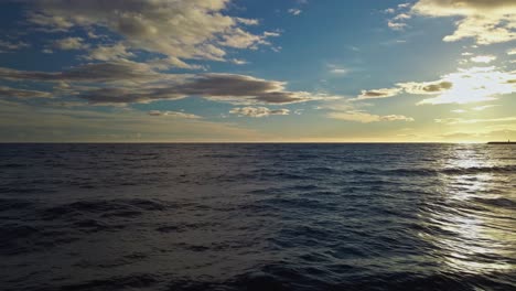 Vista-Aérea-De-Las-Olas-Del-Océano-Con-Un-Cielo-Dramático,-Muévase-Hacia-La-Playa-En-Cámara-Lenta