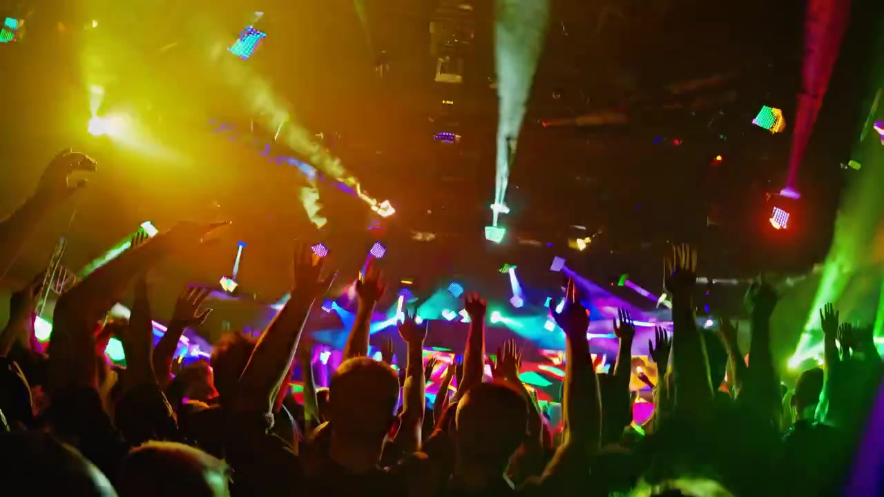 Folla entusiasta con le mani alzate a un vivace concerto in discoteca