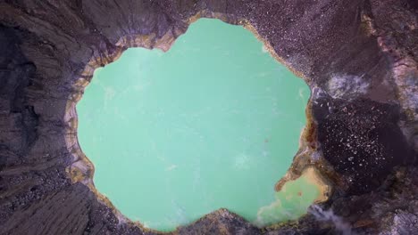 Aerial-looks-directly-down-onto-boiling-green-lake,-Santa-Ana-Volcano