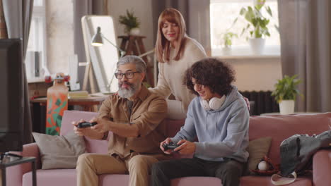 family having fun and playing console game at home