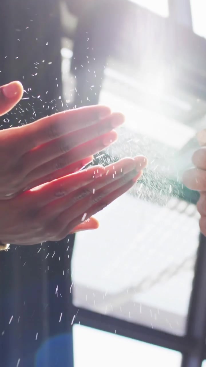 Animazione di punti luce su persone di diverse etnie che disinfettano le mani