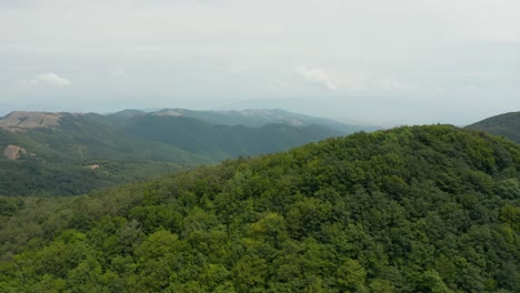 Aerial-view-flying-over-forested-mountains-and-valleys-in-Georgia